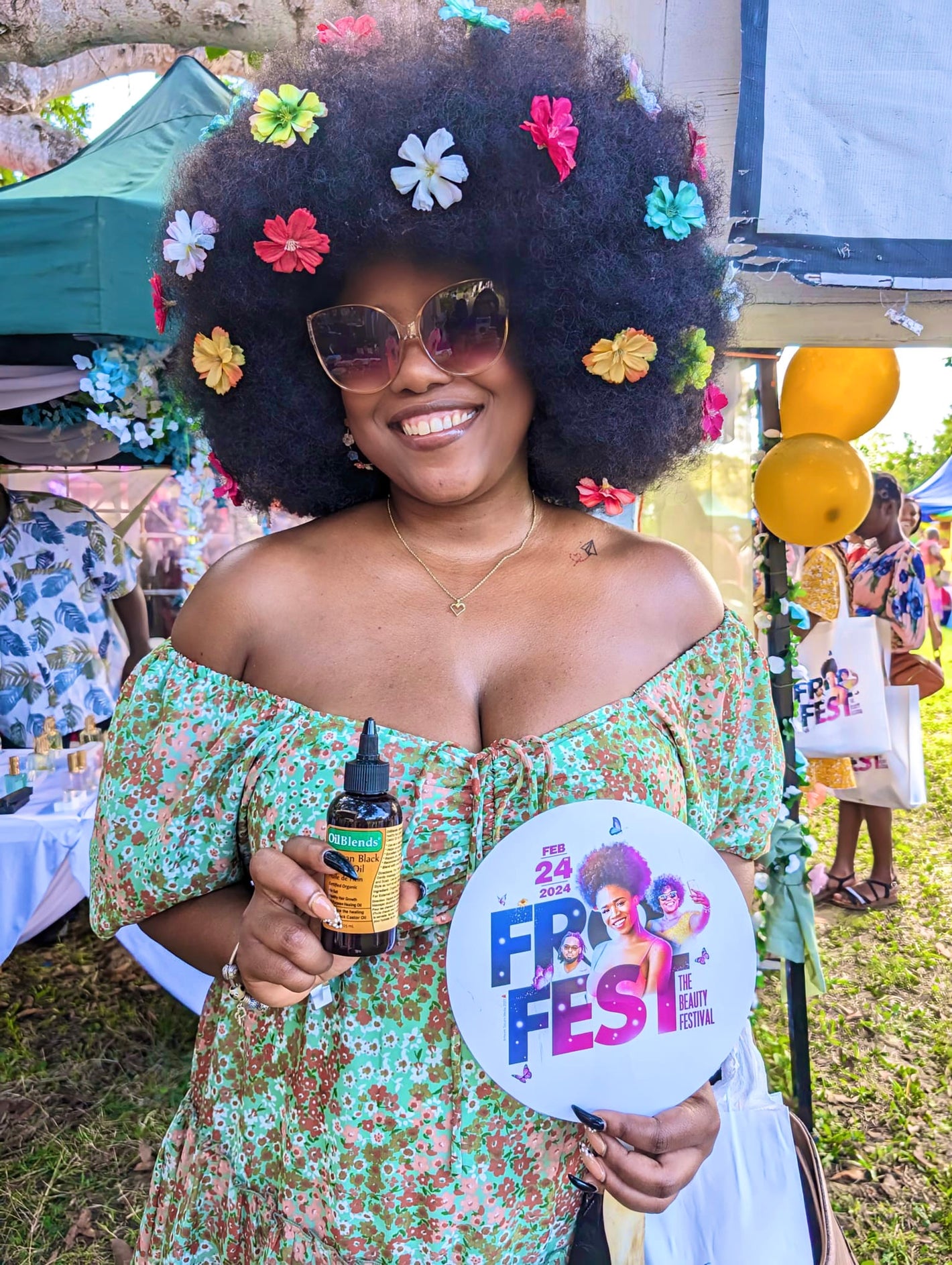 Customer with afro hair holding OilBlends Jamaican Black Castor Oil, highlighting natural hair growth, strengthening, and moisturizing benefits. Perfect for promoting healthy, fuller hair with plant-based, chemical-free ingredients. fro festival 2026 antigua, natural long hair