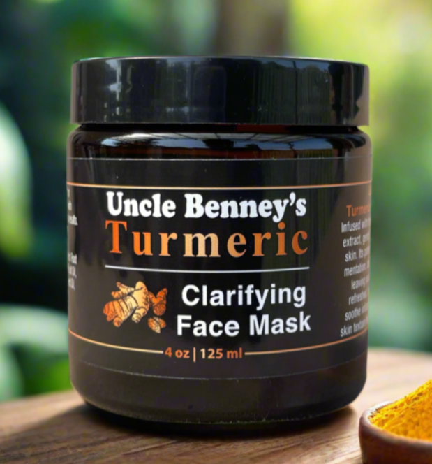 Jar of Uncle Benney's Turmeric Clarifying Face Mask on a wooden surface with a blurred green background. Ideal for all skin types, it helps soothe inflammation while improving overall skin texture for a healthy, glowing appearance. Canadian owned organic skincare brand