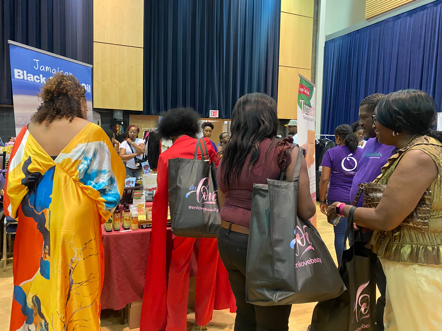 Attendees exploring OilBlends traditional plant-based beauty products at the Textured Hair and beauty show in Toronto, engaging with natural skincare displays and testing premium oils and soaps.