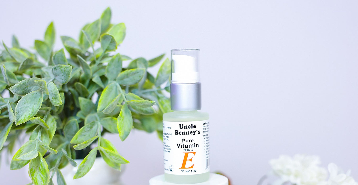 Bottle of Uncle Benney's Pure Vitamin E oil with a plant in the, reduce wrinkles naturally, how to remove scars using vitamin e